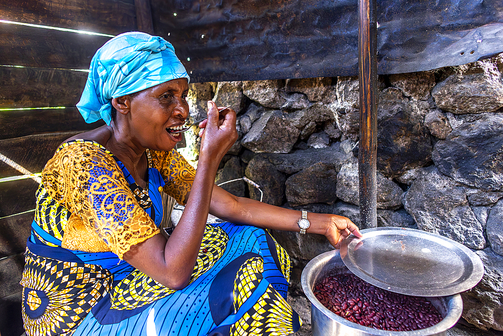 Woman tasting a dish in her kitchen in Bukavu, Democratic Republic of the Congo, Africa