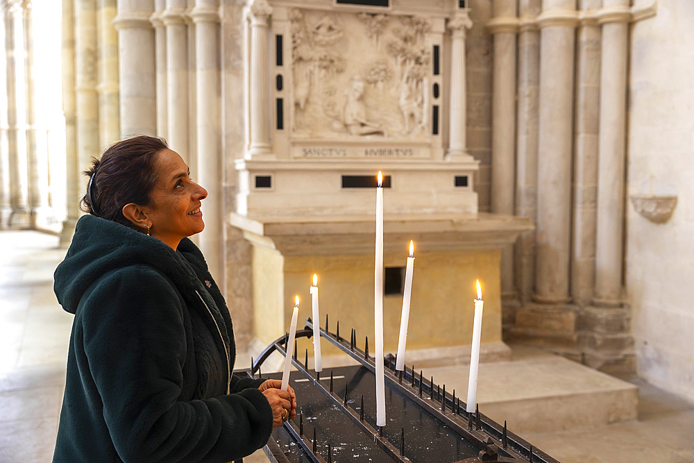 Woman holding a candle in Vezelay abbey, Sainte-Marie-Madeleine Basilica, Yonne, France