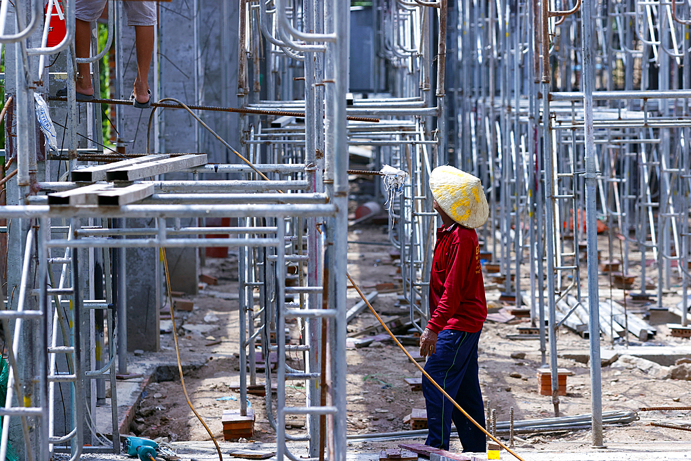 Setting up scaffolding on a construction site. Vietnamese worker. Tan Chau. Vietnam.