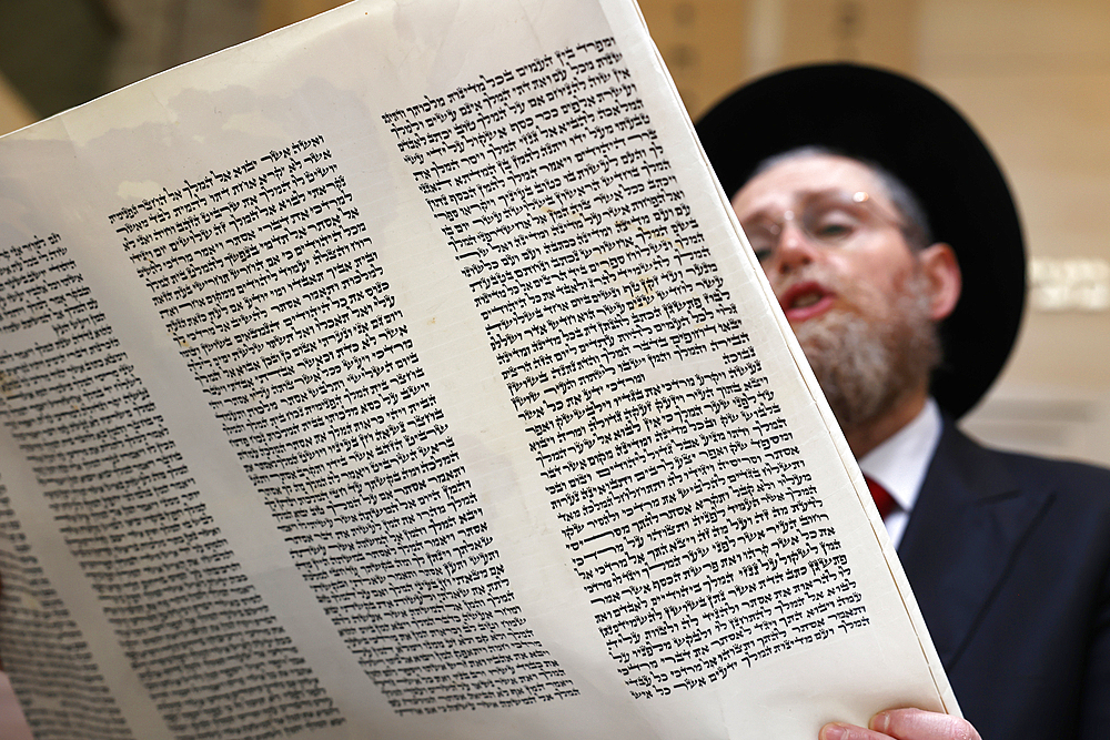 Celebration of Purim festival at Beth Loubavitch synagogue, Montrouge, France. Rabbi reading the meghilat, book of Esther