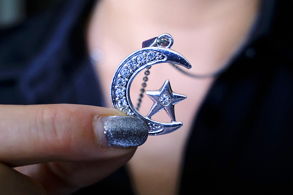 Woman wearing muslim jewelry with crescent and star. Symbol of Islam.