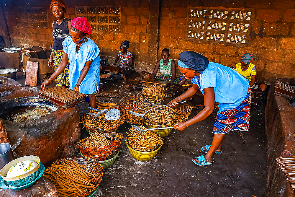 Women working in a workshop where peanuts are transformed into klui klui sticks in central Benin