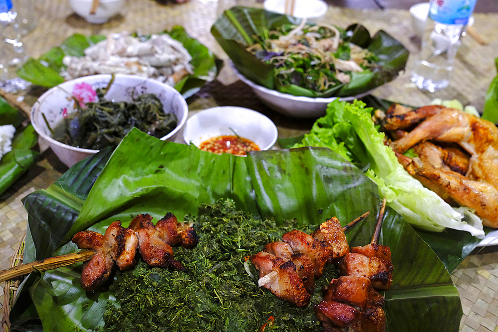 Traditional festive meal in a village on the highlands. Rice cooked over a wood fire in a bamboo pot. Kontum. Vietnam.