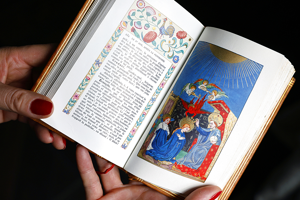 Catholic woman reading an illustrated missal. The Coronation of the Virgin in Heaven.
