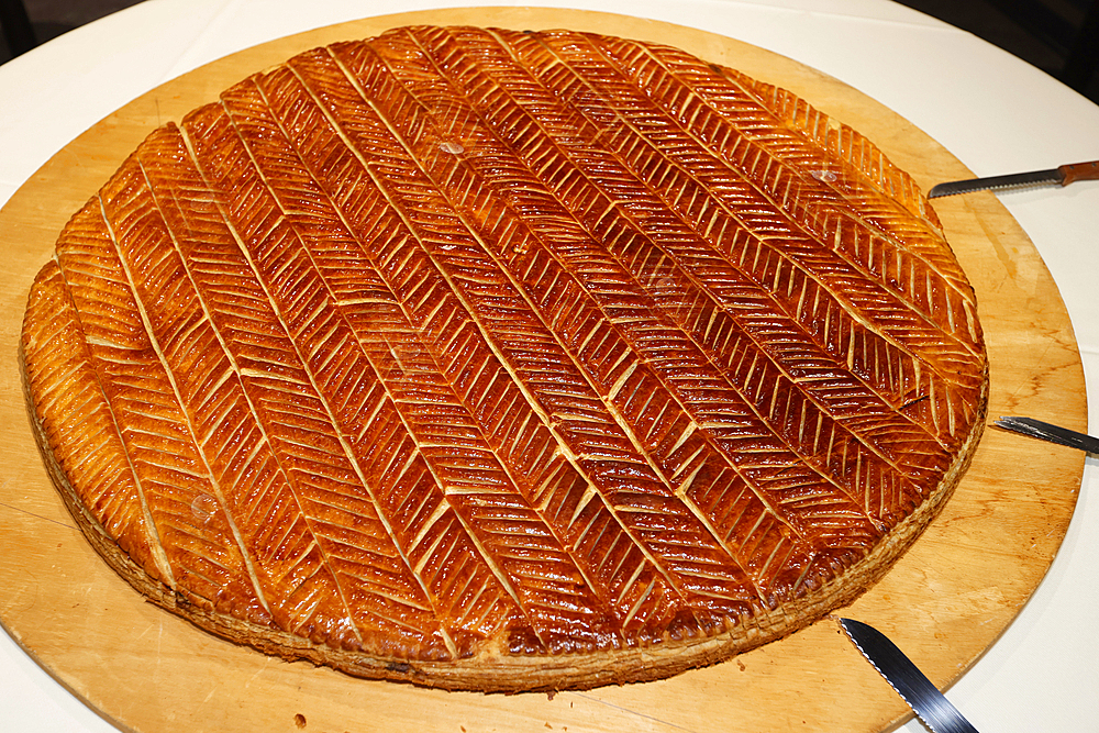 Galette des Rois (French King Cake) with Feve and Crown usually shared on the Epiphany to celebrate the arrival of the Three Wise men in Bethlehem.