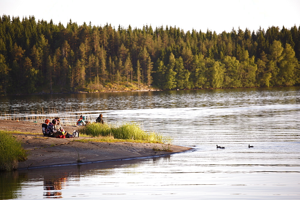 Young people relaxing beside lake, Savonlinna, Saimaa Lake District, Savonia, Finland, Scandinavia, Europe