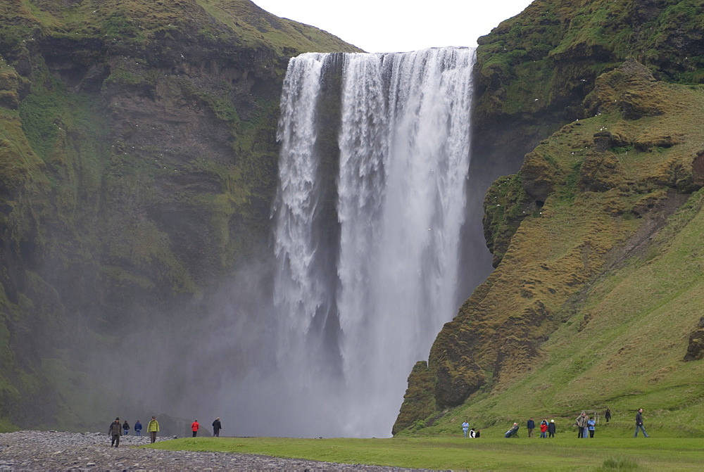 People admiring the big waterfall of Skogarfoss, Iceland, Polar Regions