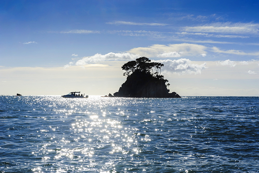 Backlight of a lonely rock sitting in the ocean, Abel Tasman National Park, South Island, New Zealand, Pacific