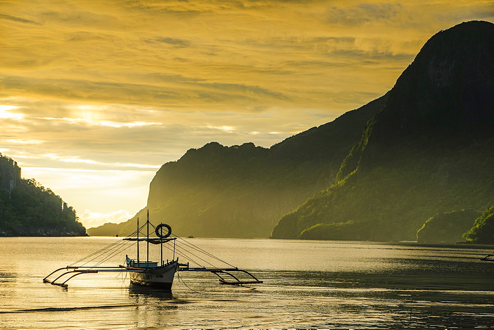 Outrigger at sunset in the bay of El Nido, Bacuit Archipelago, Palawan, Philippines, Southeast Asia, Asia