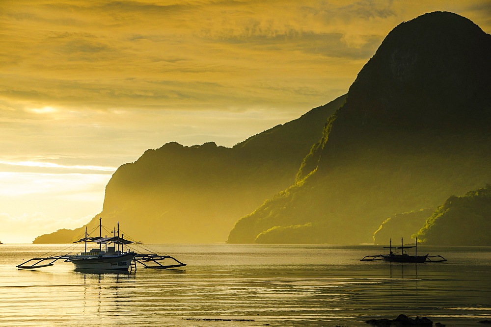 Outrigger at sunset in the bay of El Nido, Bacuit Archipelago, Palawan, Philippines, Southeast Asia, Asia