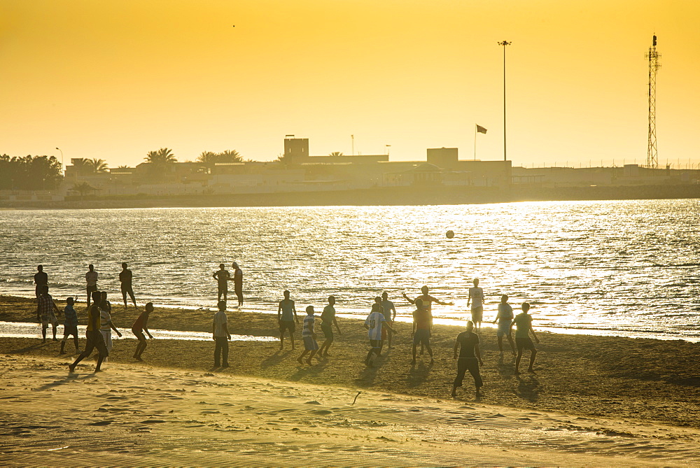 Backlight at men playing soccer at the beach of Bukha, Musandam, Oman, Middle East