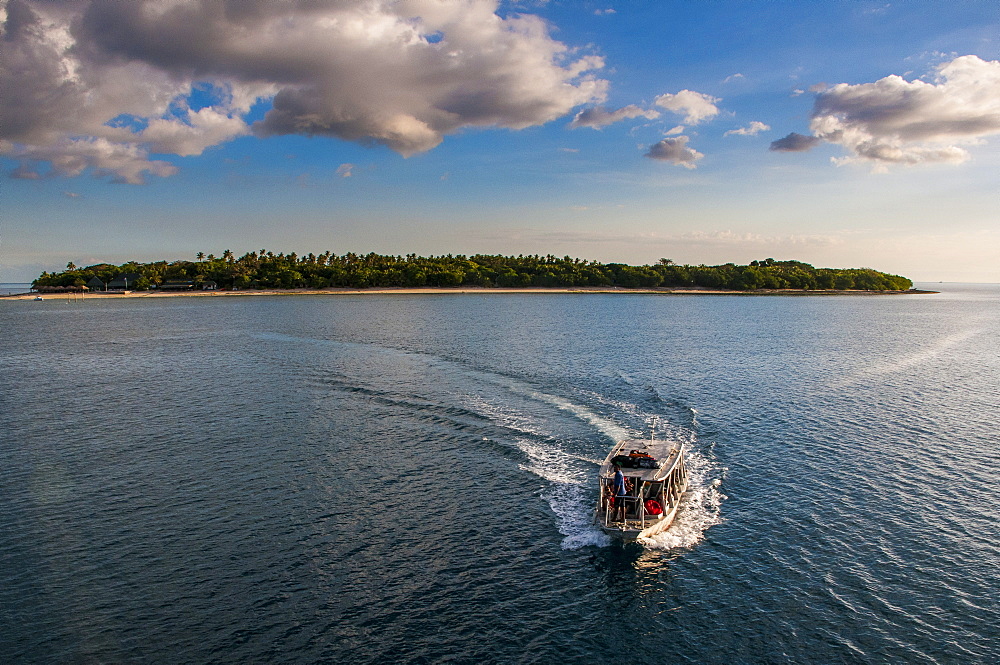 Little boat with an island beyond, Mamanucas Islands, Fiji, South Pacific, Pacific