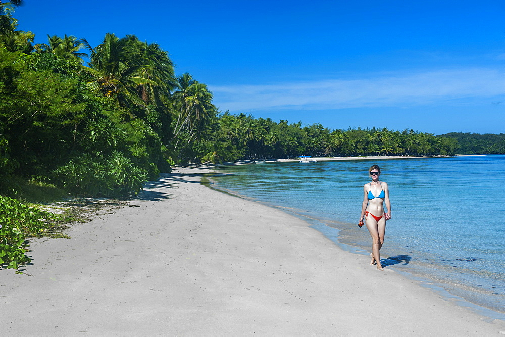 Woman walking on a a white sand beach, Nanuya Lailai island, the blue lagoon, Yasawas, Fiji, South Pacific, Pacific