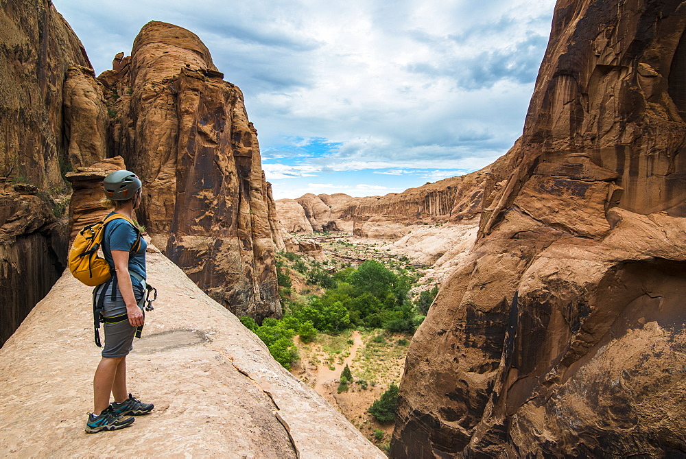 Woman standing on a giant arch near Moab, Utah, United States of America, North America