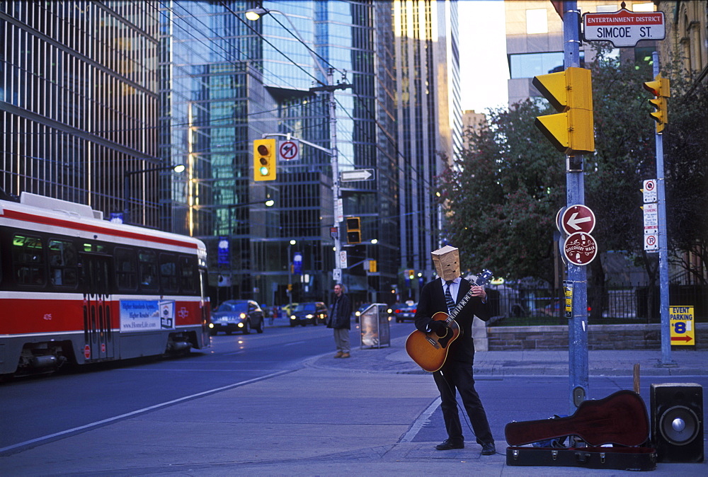 Street musician playing guitar with brown paper bag covering his head, Toronto, Ontario, Canada, North America