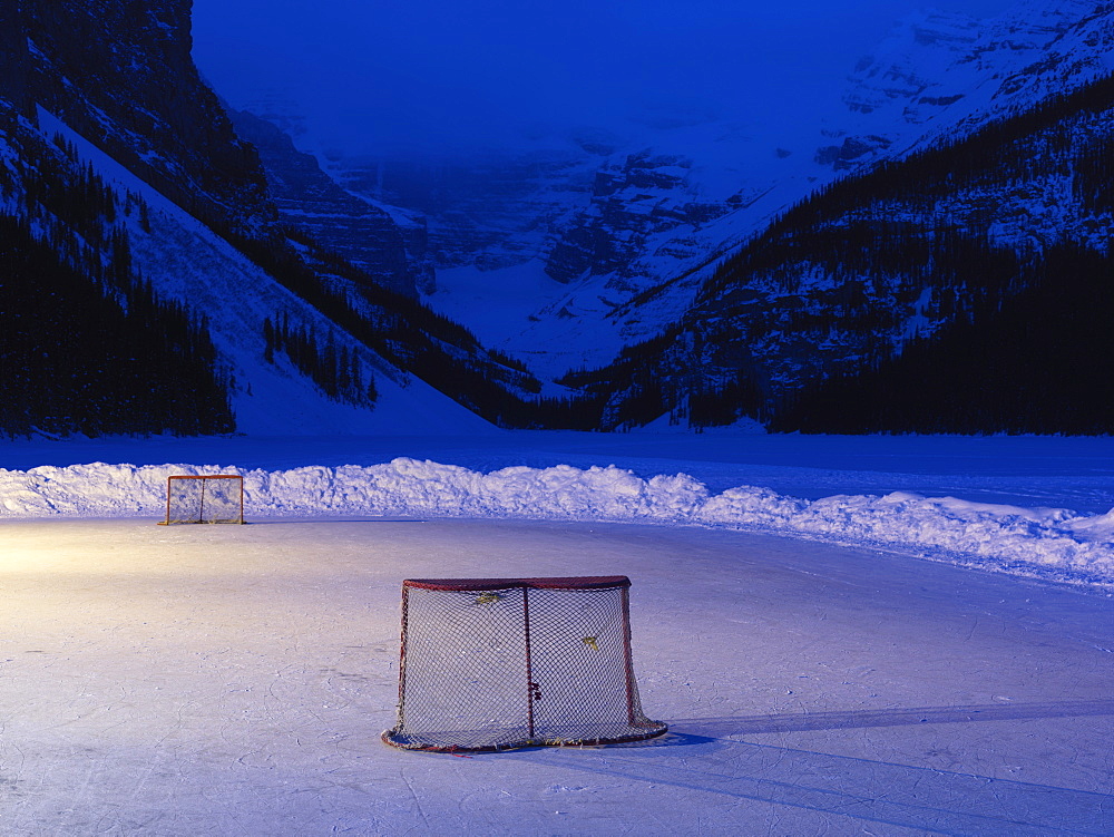 Ice rink with hockey nets on frozen Lake Louise at dawn, Banff National Park, Alberta, Canada, North America