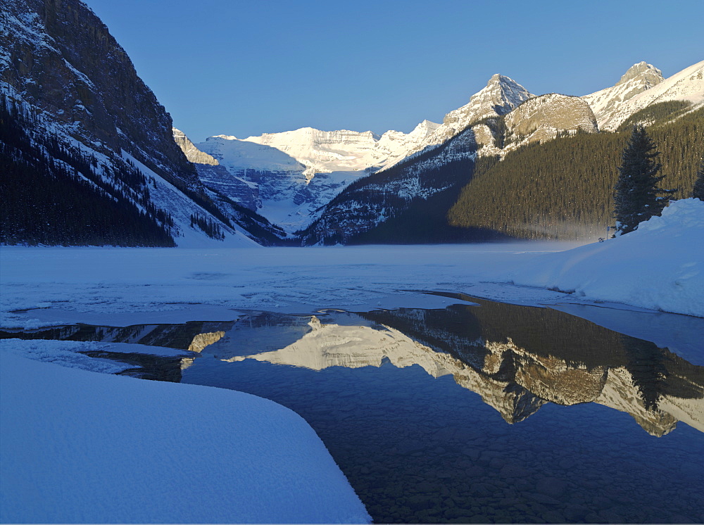 Sunrise on Mount Victoria on Lake Louise with reflection on frozen lake, Lake Louise, Banff National Park, UNESCO World Heritage Site, Alberta, Canada, North America