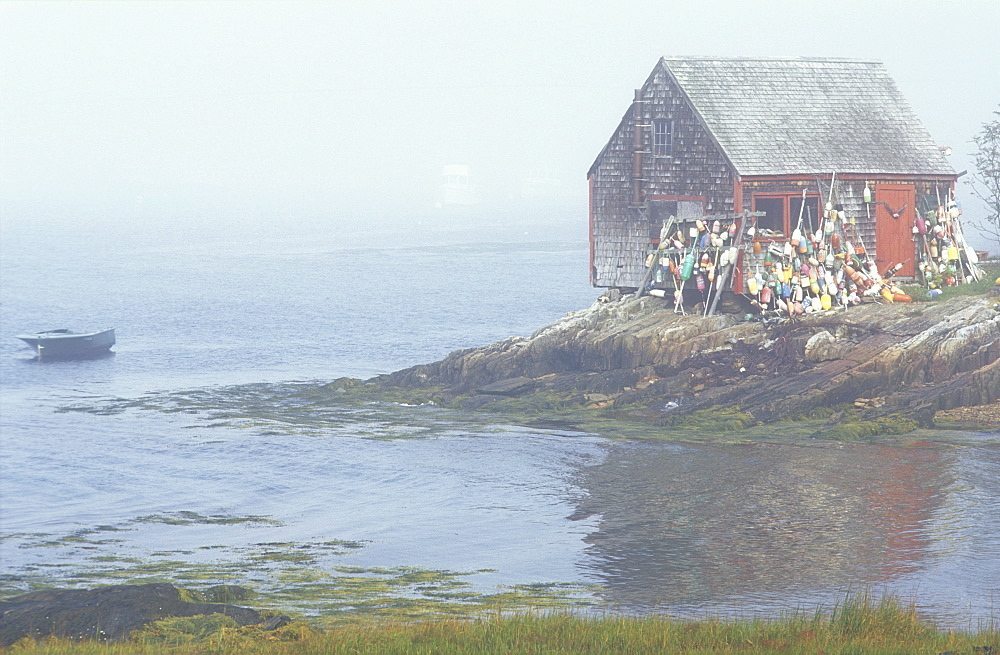 Lobster shack with lobster buoys perched on a rocky shoreline with the ocean in the background, Lands End, Maine, United States of America, North America