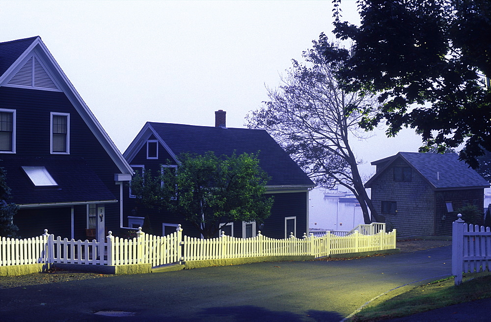 Homes with picket fences along a sreet illuminated at dawn, Camden, Maine, New England, United States of America, North America