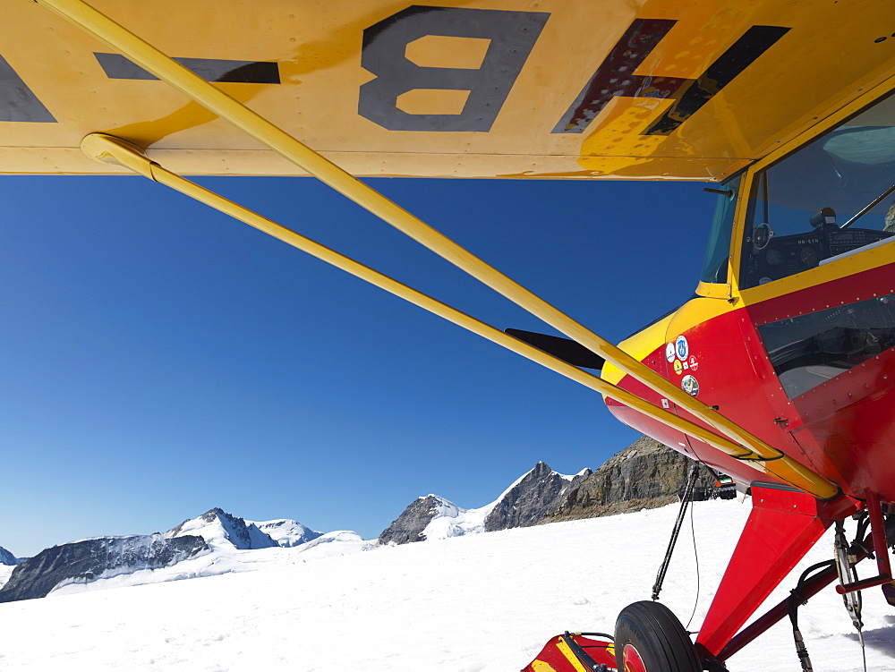 Airplane on glacier with mountains in background, The Great Aletsch Glacier, the longest glacier in the Alps, begins on the Jungfraujoch (Top of Europe), Switzerland, Europe