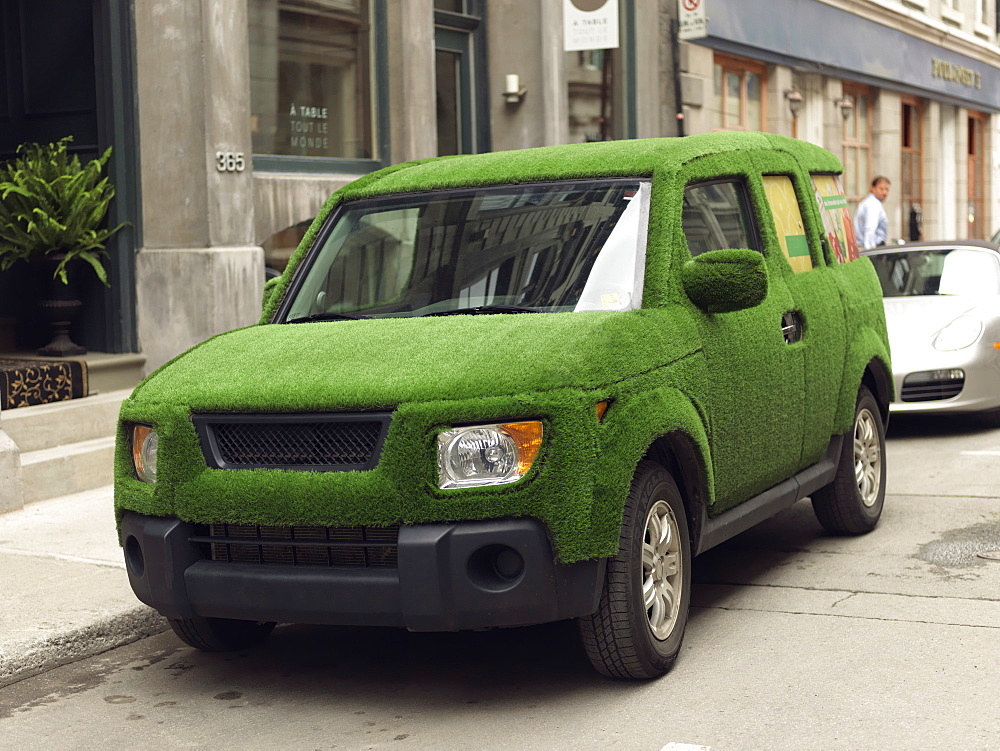 SUV covered in green grass portraying an enviro-friendly automobile, Quebec, Canada, North America