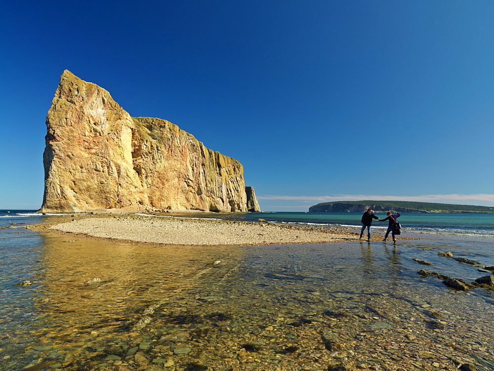 Perce Rock at low tide and couple walking out towards it, Perce, Gaspesie, Quebec, Canada, North America