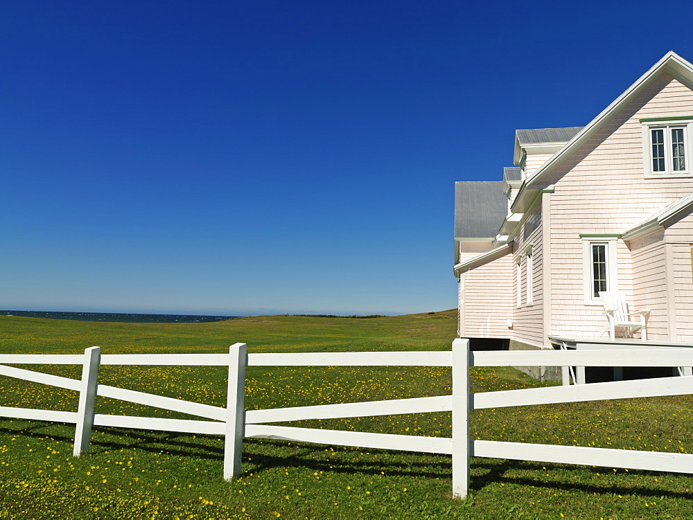 Pink house and with white fence against a blue sky, Riviere-la-Madeleine, Gaspesie, Quebec, Canada, North America