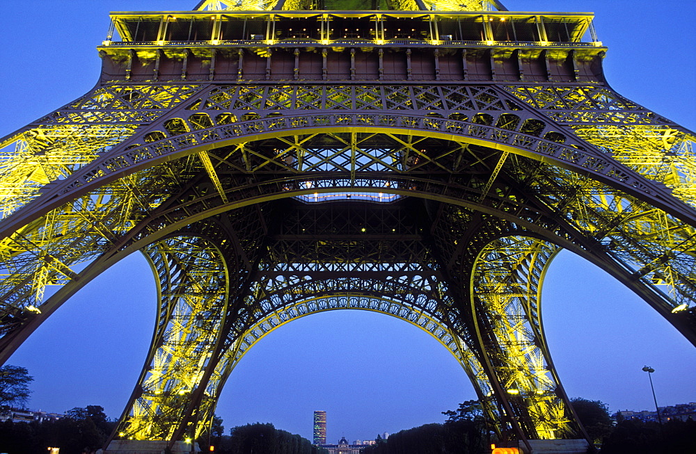 The Eiffel Tower illuminated at night, low wide angle view from below the tower, Paris, France, Europe