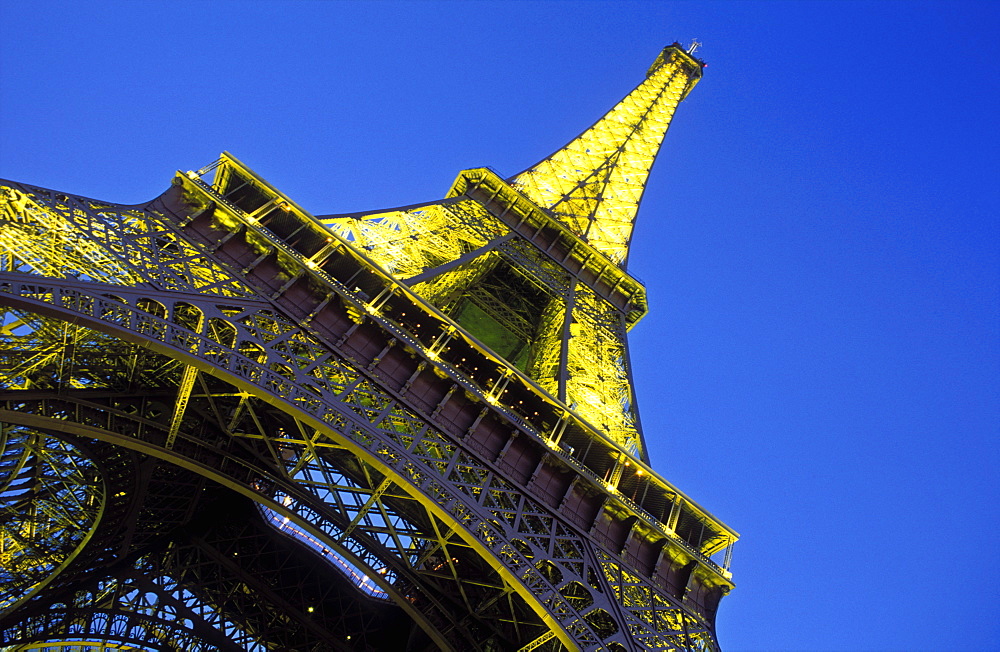 The Eiffel Tower illuminated at night, low wide angle view from below the tower, Paris, France, Europe