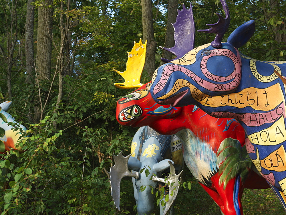 Painted moose sculptures in a forest setting, Ivy Lea, Ontario, Canada, North America