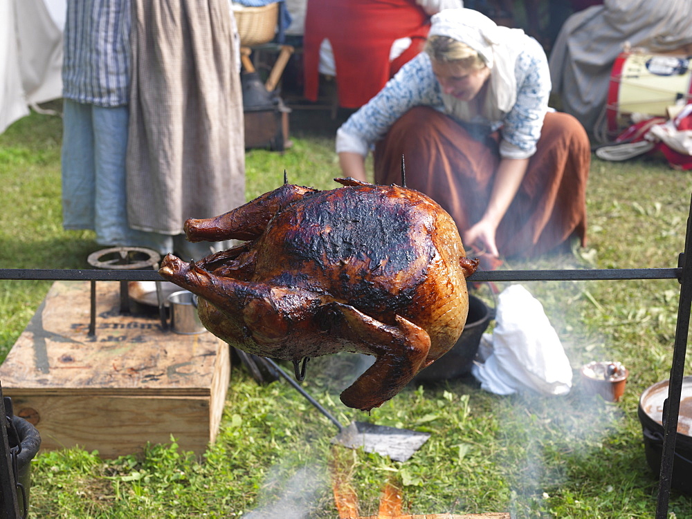 French-Indian War reenactment, woman cooking a turkey over an open fire, Fort Niagara, Youngstown, New York State, United States of America, North America