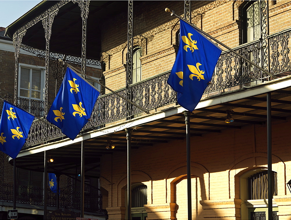 French Quarter building with wrought iron balconies and fleurs de lys flags, New Orleans, Louisiana, United States of America, North America