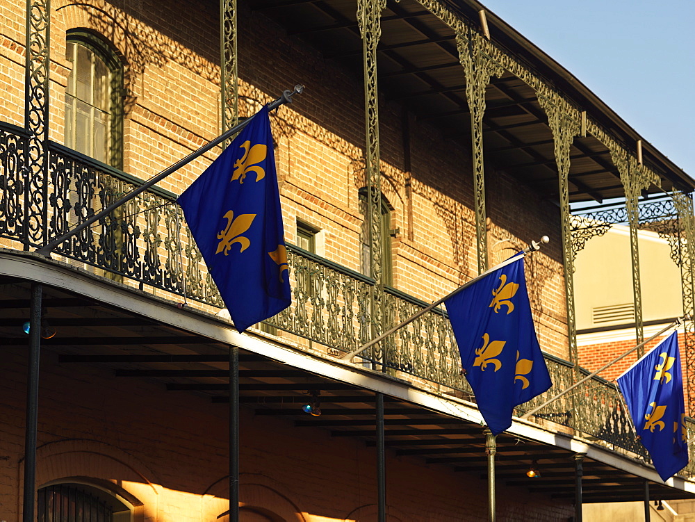 French Quarter building with wrought iron balconies and fleurs de lys flags, New Orleans, Louisiana, United States of America, North America