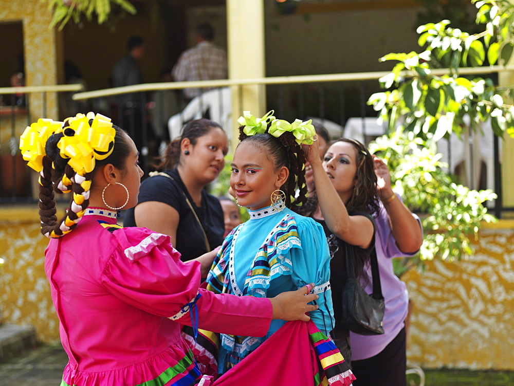 Portrait of a young Mexican girl dancer in folkloric costume being dressed up by friends, Tequila, Jalisco, Mexico, North America