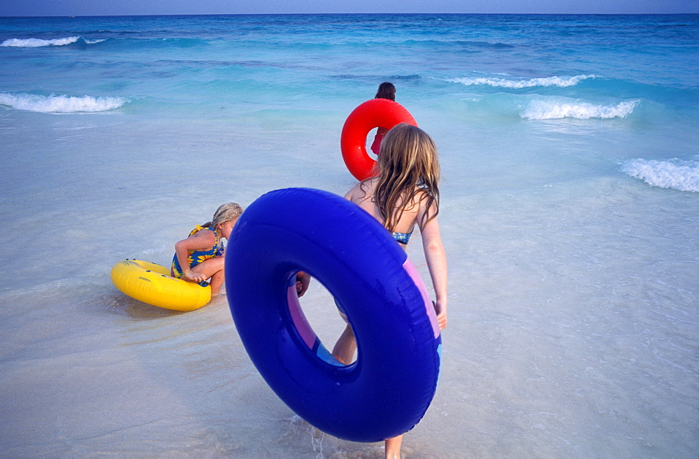 Three young girls playing in the surf, Playa del Carmen, Mexico, North America