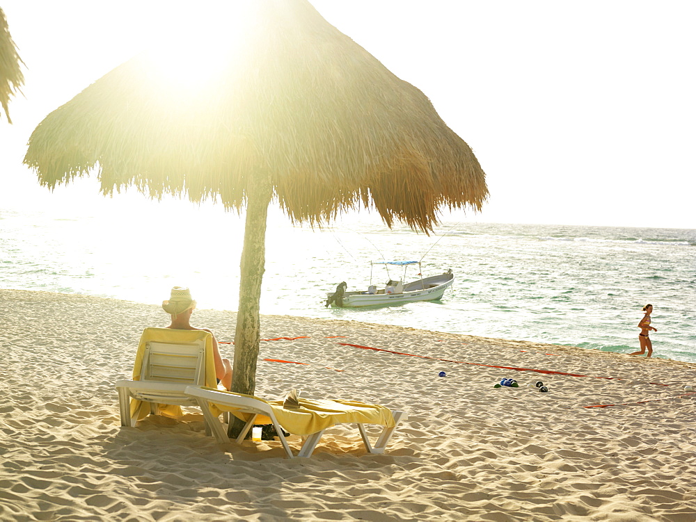 Man relaxing under palapa on beach, Mayan Riviera, Akumal, Yucatan, Quintana Roo, Mexico, North America