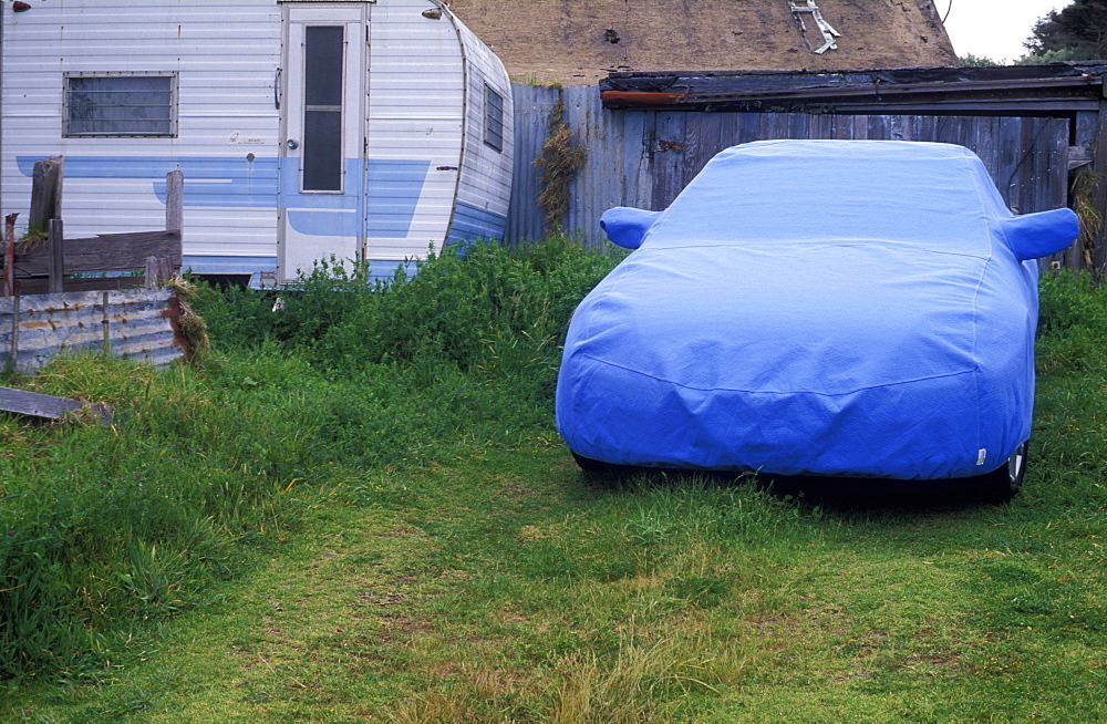 Old house trailer and car with cover on vacant lot, Mendocino, California, United States of America, North America