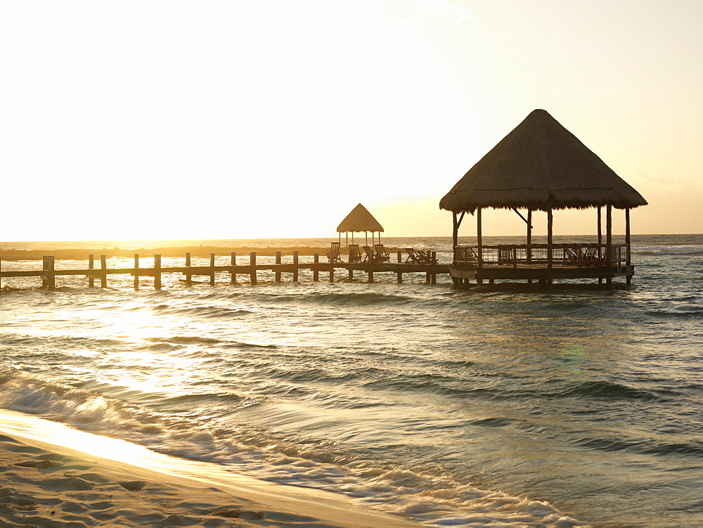 Pier with palapa jutting out into the water from the beach at sunrise, Mayan Riviera, Akumal, Yucatan, Quintana Roo, Mexico, North America