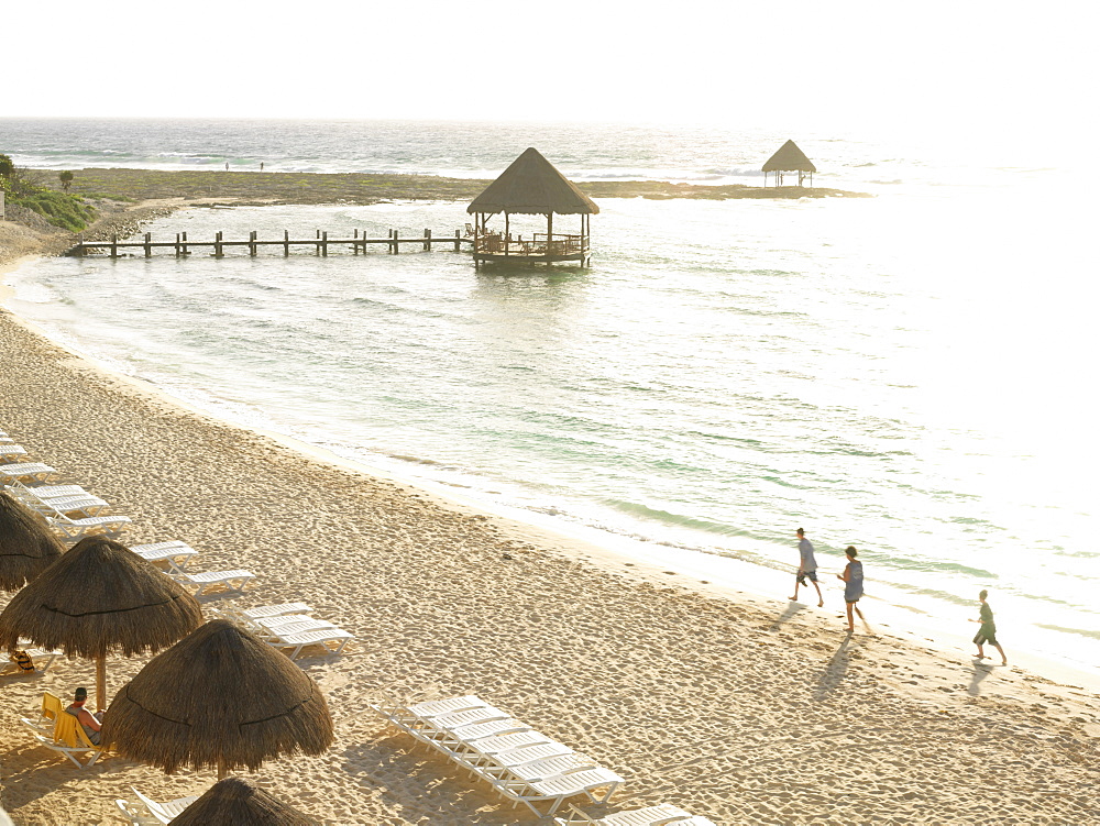 Seaside beach scene with palapa and beach chairs with bright sunlight reflecting off of the water, Mayan Riviera, Akumal, Yucatan, Quintana Roo, Mexico, North America