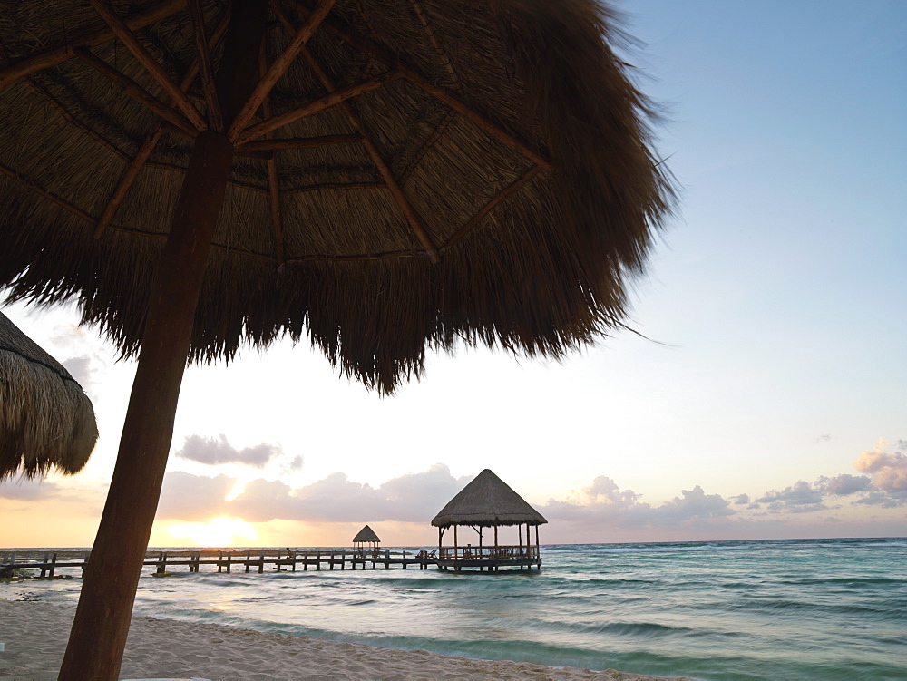 Pier with palapa jutting out into the water from the beach at sunrise, Mayan Riviera, Akumal, Yucatan, Quintana Roo, Mexico, North America