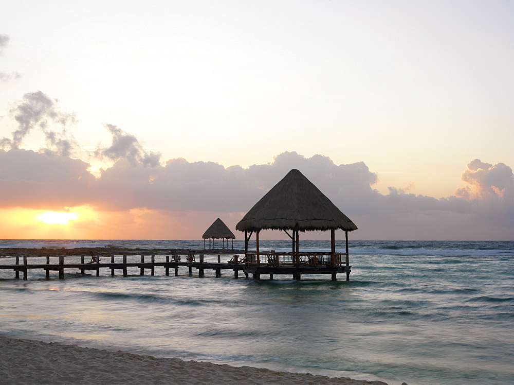 Pier with palapa jutting out into the water from the beach at sunrise, Mayan Riviera, Akumal, Yucatan, Quintana Roo, Mexico, North America