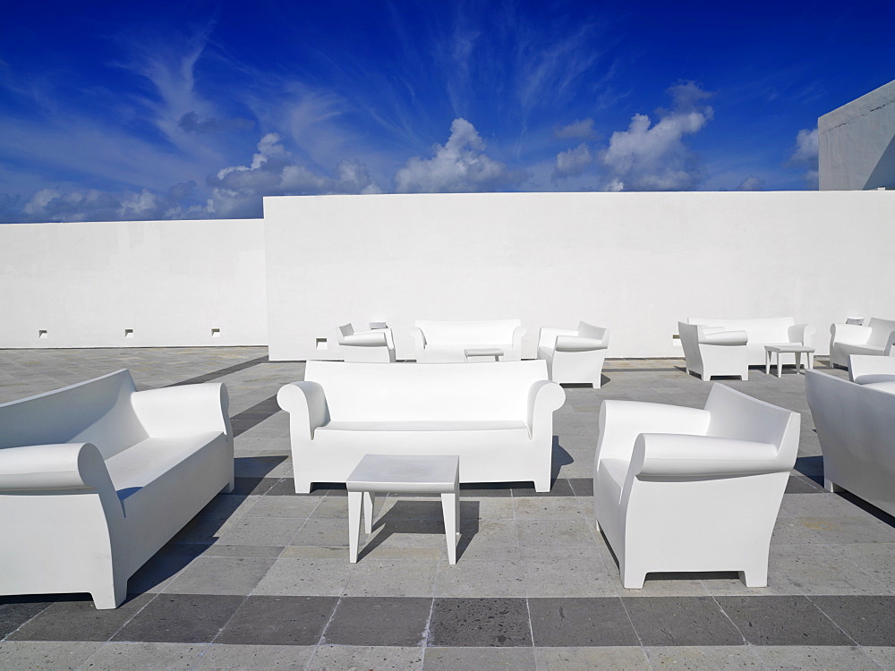 White chairs and white couches against a white wall and blue sky in a surreal setting, Mayan Riviera, Akumal, Yucatan, Quintana Roo, Mexico, North America