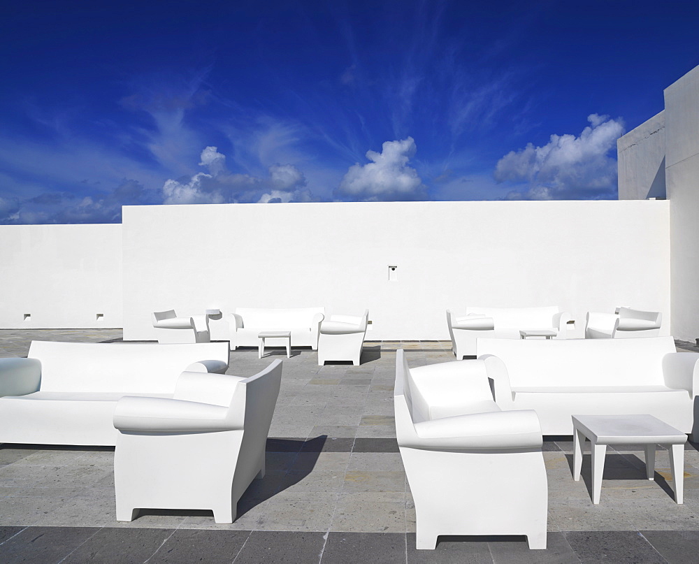 White chairs and white couches against a white wall and blue sky in a surreal setting, Mayan Riviera, Akumal, Yucatan, Quintana Roo, Mexico, North America