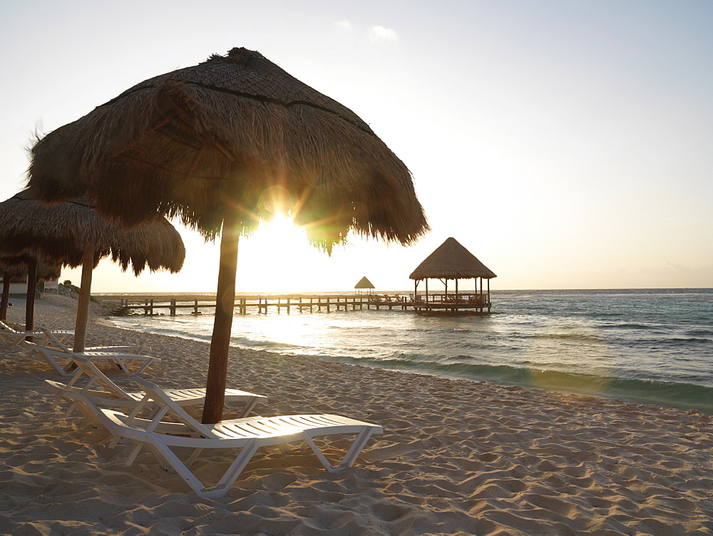 Palapa on beach, with pier beyond at sunrise, Mayan Riviera, Akumal, Yucatan, Quintana Roo, Mexico, North America