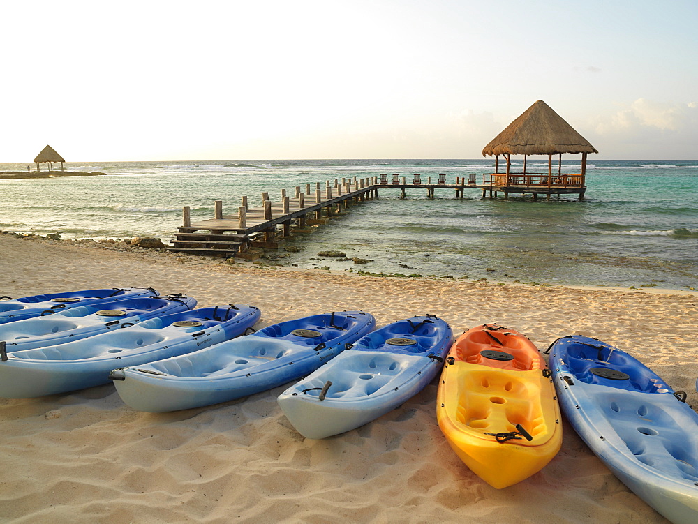 Kayaks on the beach and pier with palapa jutting out into the water from the beach, Mayan Riviera, Akumal, Yucatan, Quintana Roo, Mexico, North America