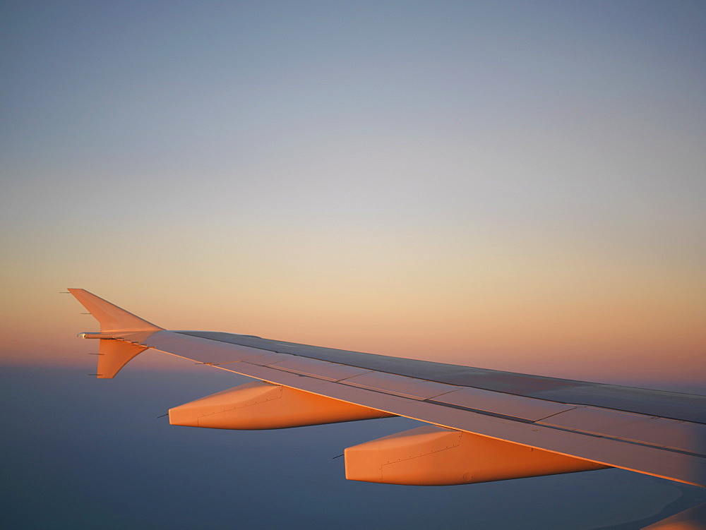 Airplane wing against a blue sky at dusk above Cancun, Mexico, North America