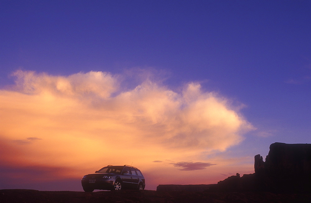 Car against cloud at sunrise, Monument Valley Navajo Tribal Park, Arizona, United States of America, North America