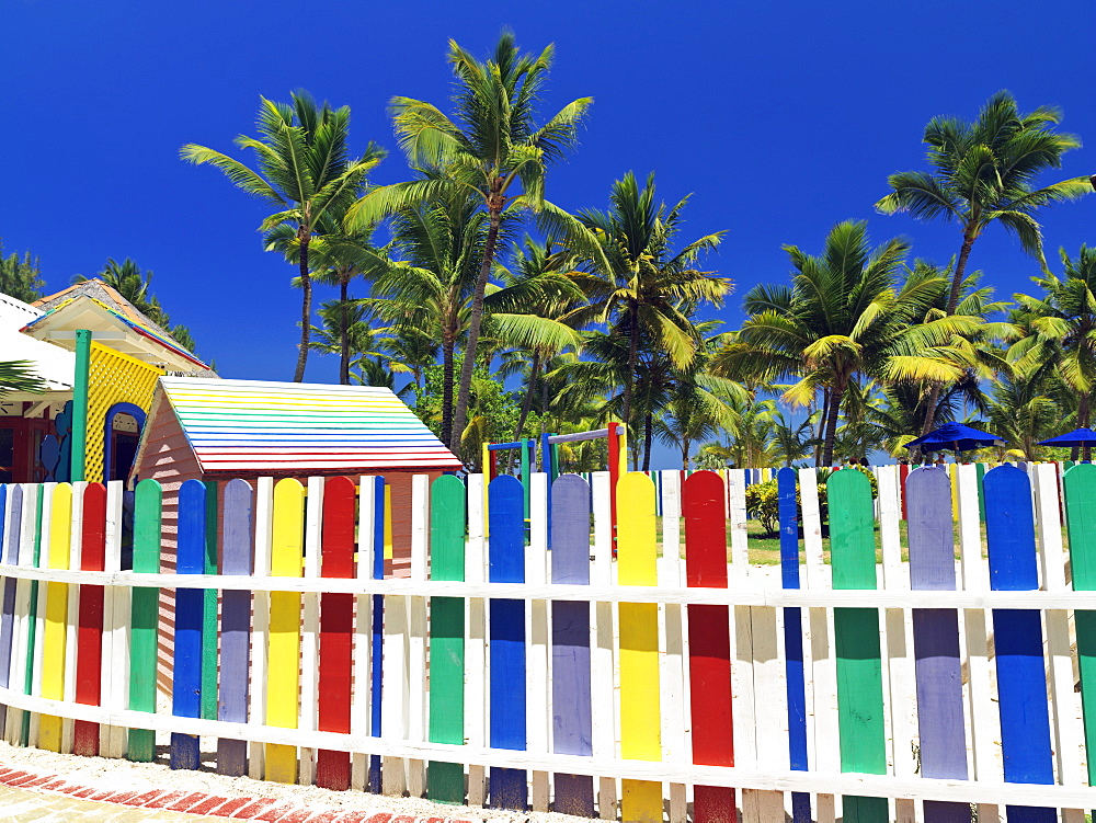 Multi-colored picket fence and palm trees on beach, Bavaro Beach, Punta Cana, Dominican Republic, West Indies, Caribbean, Central America