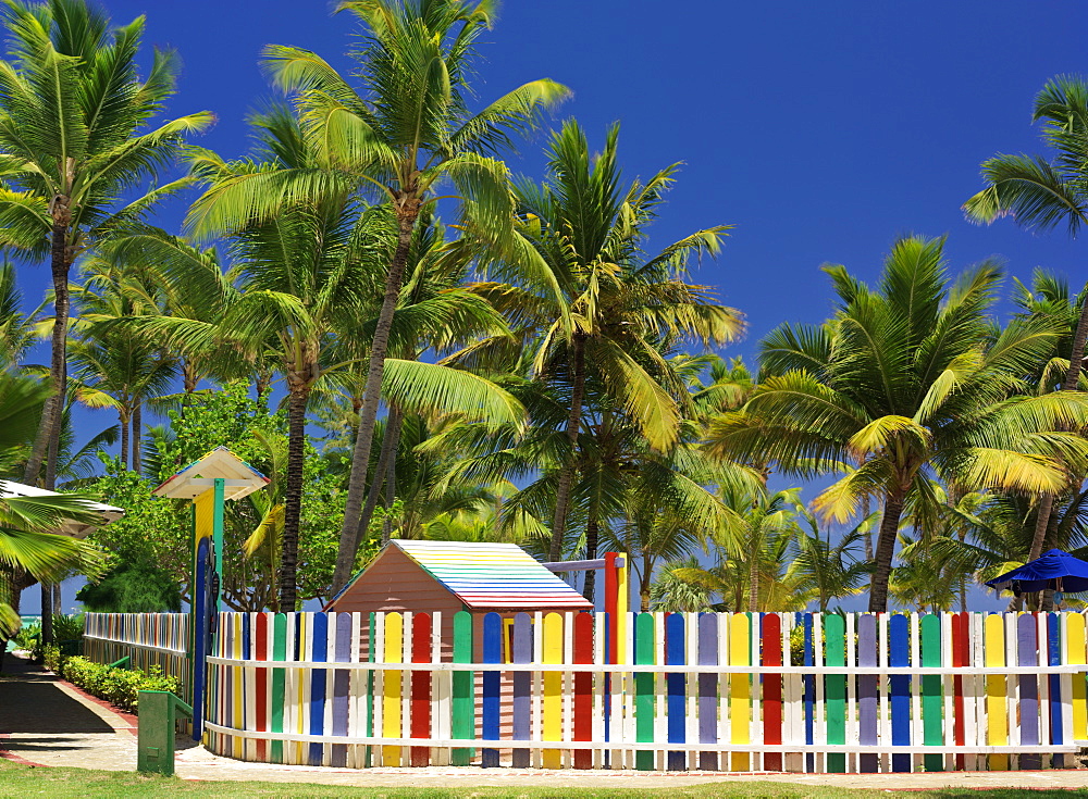 Multi-colored picket fence and palm trees on beach, Bavaro Beach, Punta Cana, Dominican Republic, West Indies, Caribbean, Central America