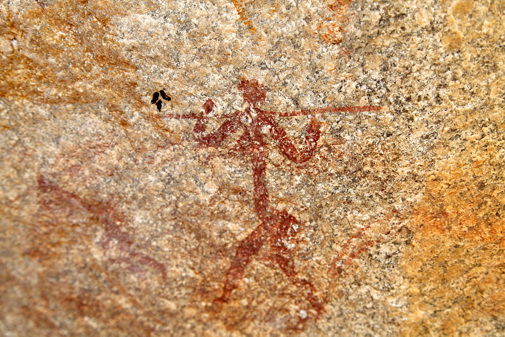 Ancient rock art of painting depicting a human carrying a spear, at Matobo National Park, Zimbabwe, Africa